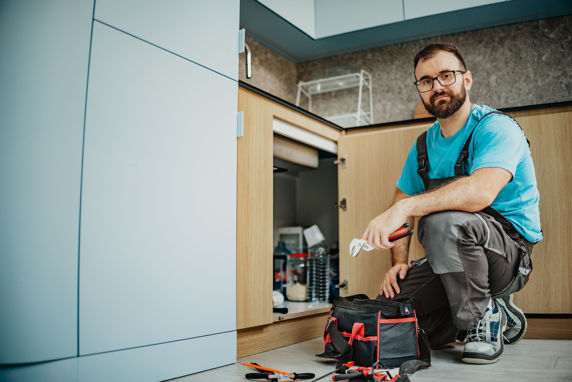 Man in work uniform ready to fix sink